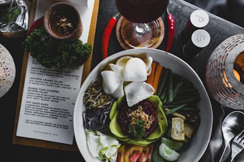 Salad bowl with steamed veggies and red rice on table in restaurant