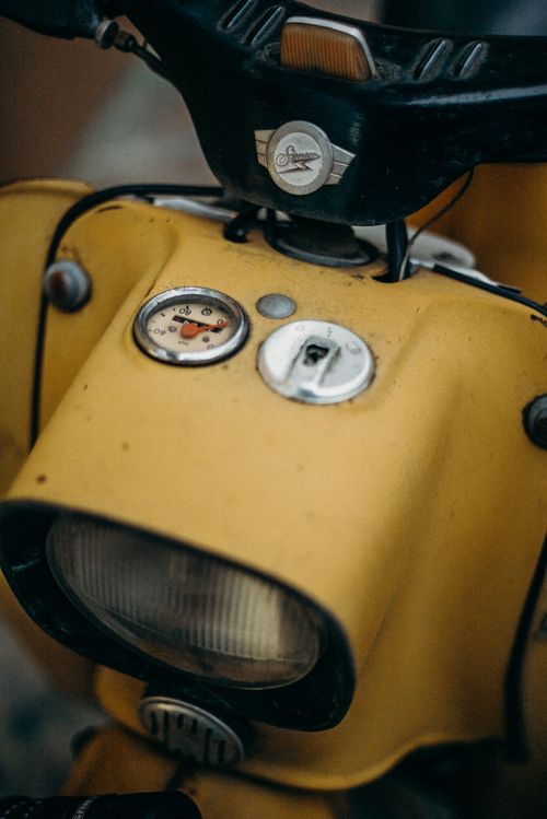 Free Detailed view of a vintage yellow motorcycle dash with headlight and speedometer. Stock Photo