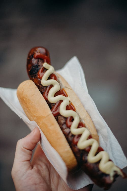 Free Person Holding Hotdog Sandwich With Ketchup Stock Photo