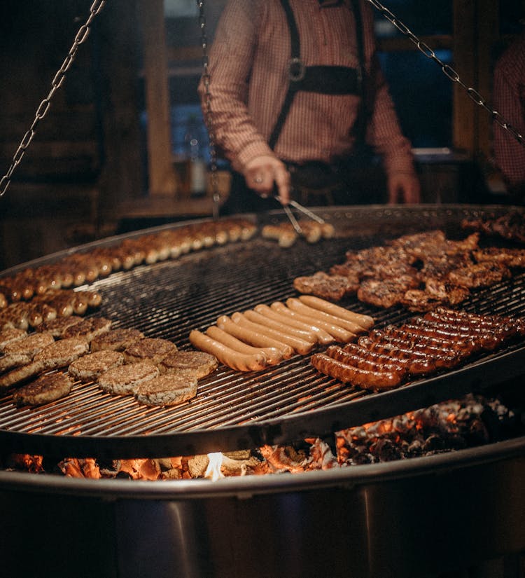 Person Cooking Meat On Grill