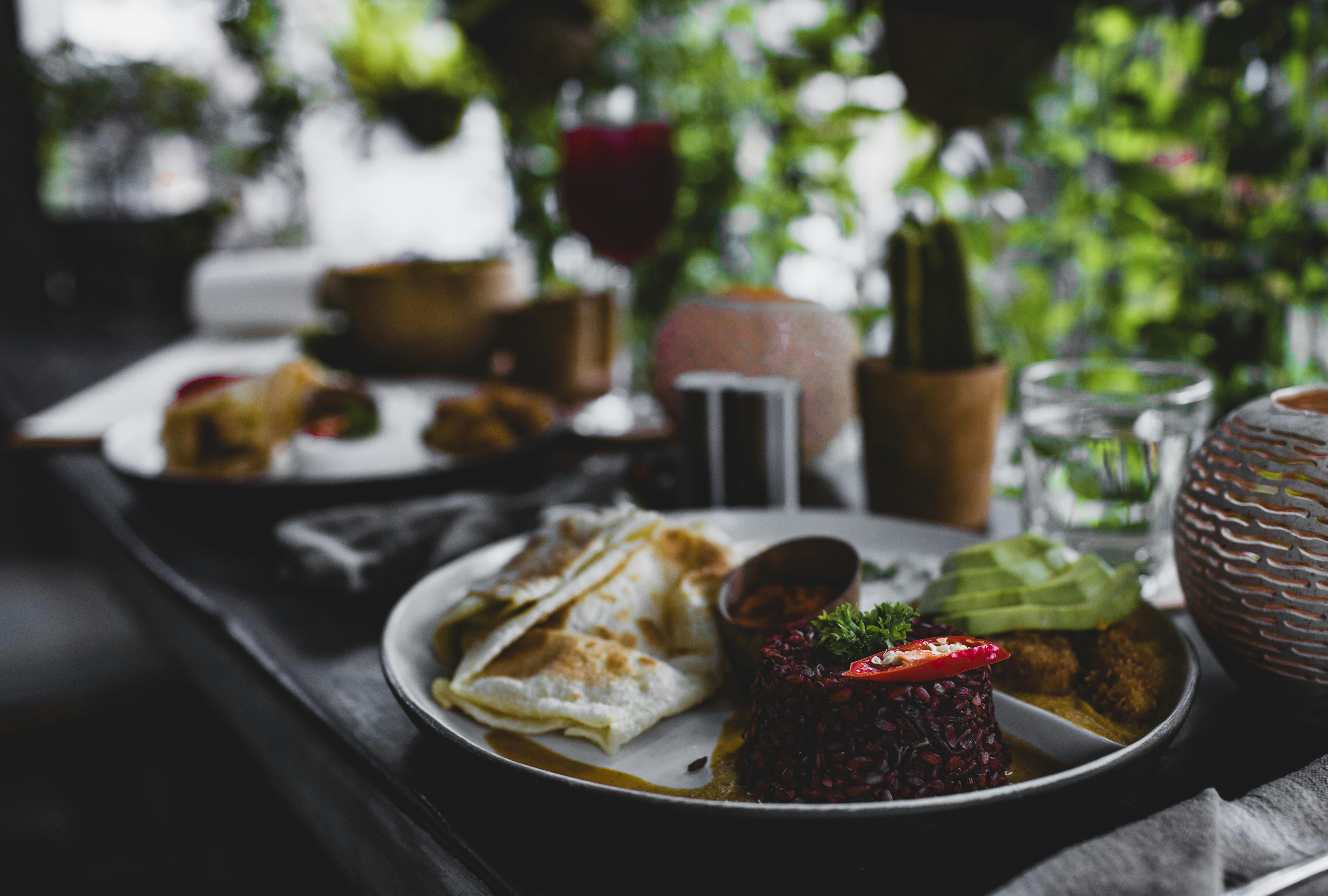 plate with tasty asian food on terrace of cafe