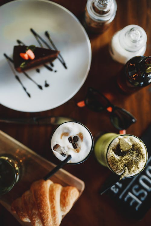 Free Table with served chocolate cake croissant and iced drinks Stock Photo