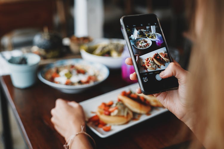 Crop Woman Taking Shot Of Food On Mobile Phone During Lunch