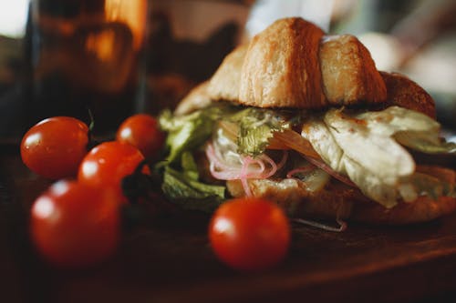 Free Crunchy veggie croissant sandwich served on board with tomatoes Stock Photo
