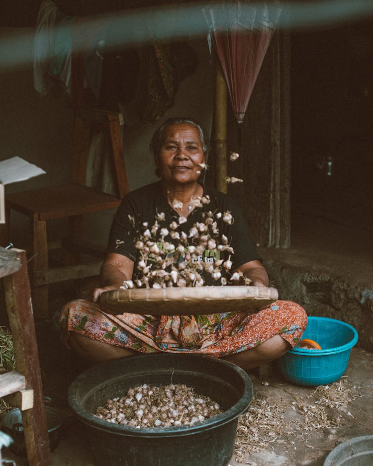 Ethnic Senior Female Working In Typical Hut