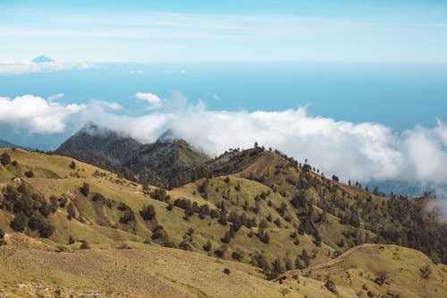 Steep slopes of mountainous terrain under clouds