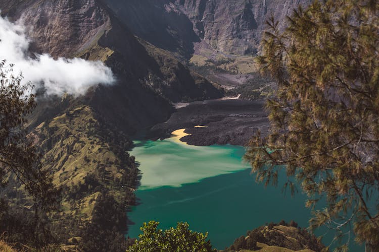 Crater Lake Between Volcanic Mountains On Sunny Day