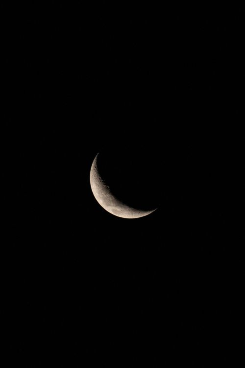 Free A crescent moon shines brightly in a dark night sky, offering a serene lunar view. Stock Photo
