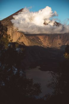 雄伟的山峰被云层包裹，在山谷上方投下阴影