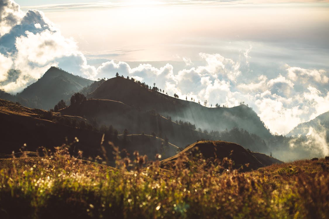 Free Hills in bright sunshine and clouds at sunset Stock Photo