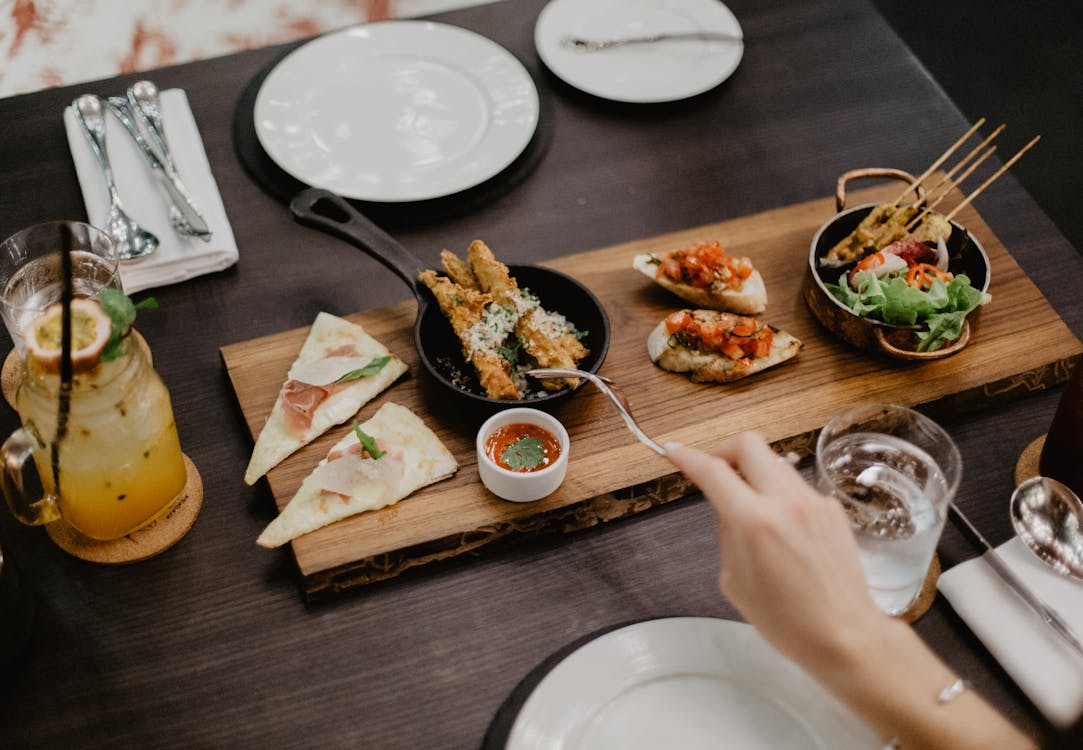 Free Crop woman eating delicious diverse meal in restaurant Stock Photo