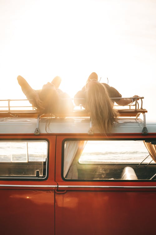 Free Friends lying on trunk of retro car  on sunny day Stock Photo