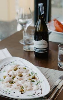 Sophisticated dining setup featuring a gourmet dish paired with Pinot Grigio wine.