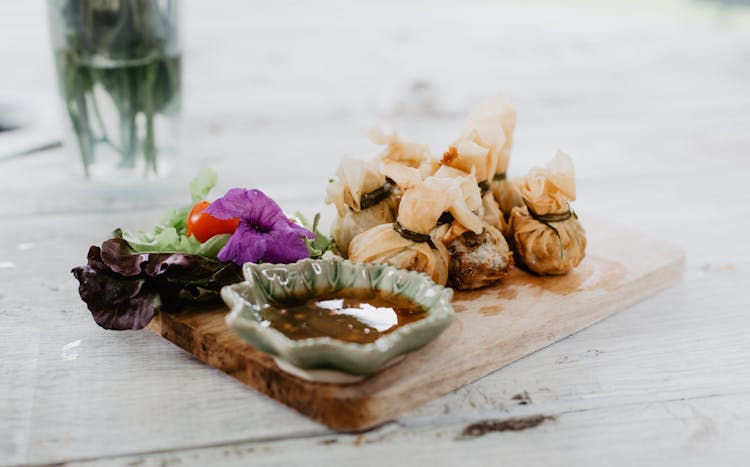 Dim Sum And Vegetables On Wooden Board In Cafe