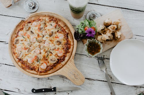 Pizza and dim sum on table in cafe