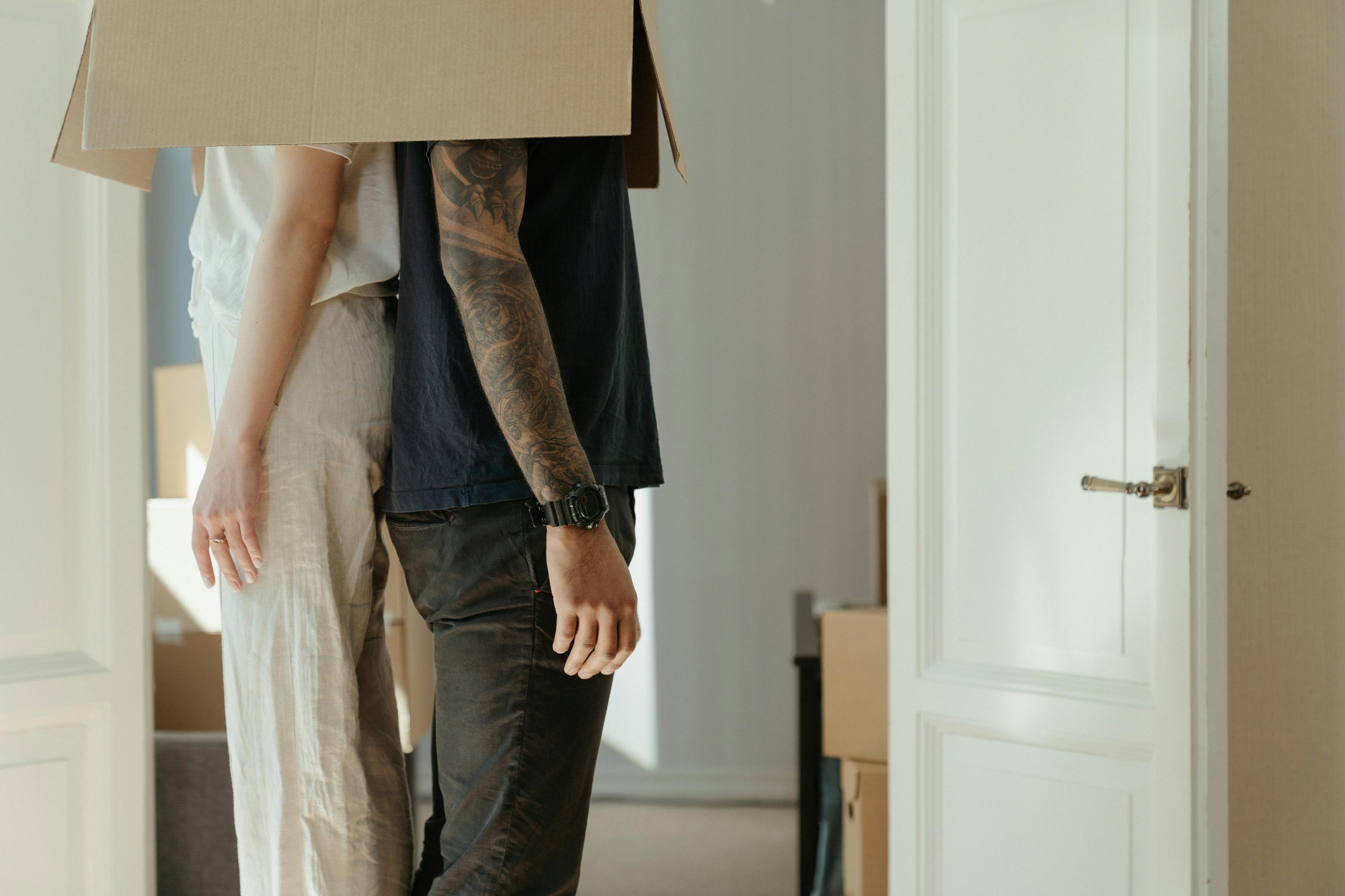 woman in blue denim jeans holding brown cardboard box