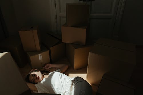 Man in White T-shirt Lying on Bed