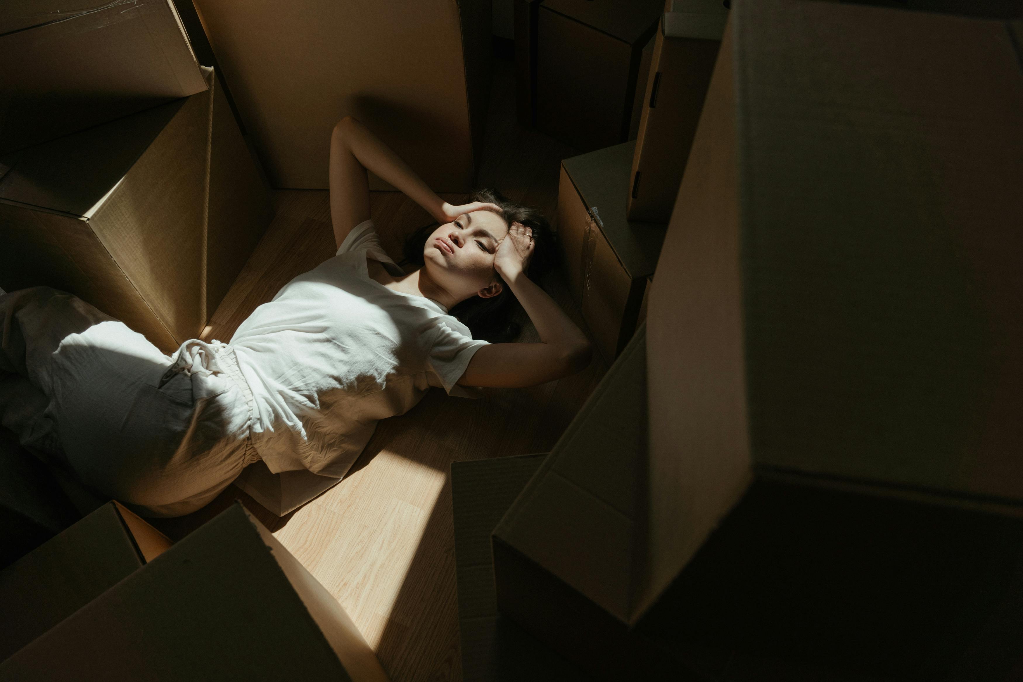 woman in white t shirt lying on brown cardboard box