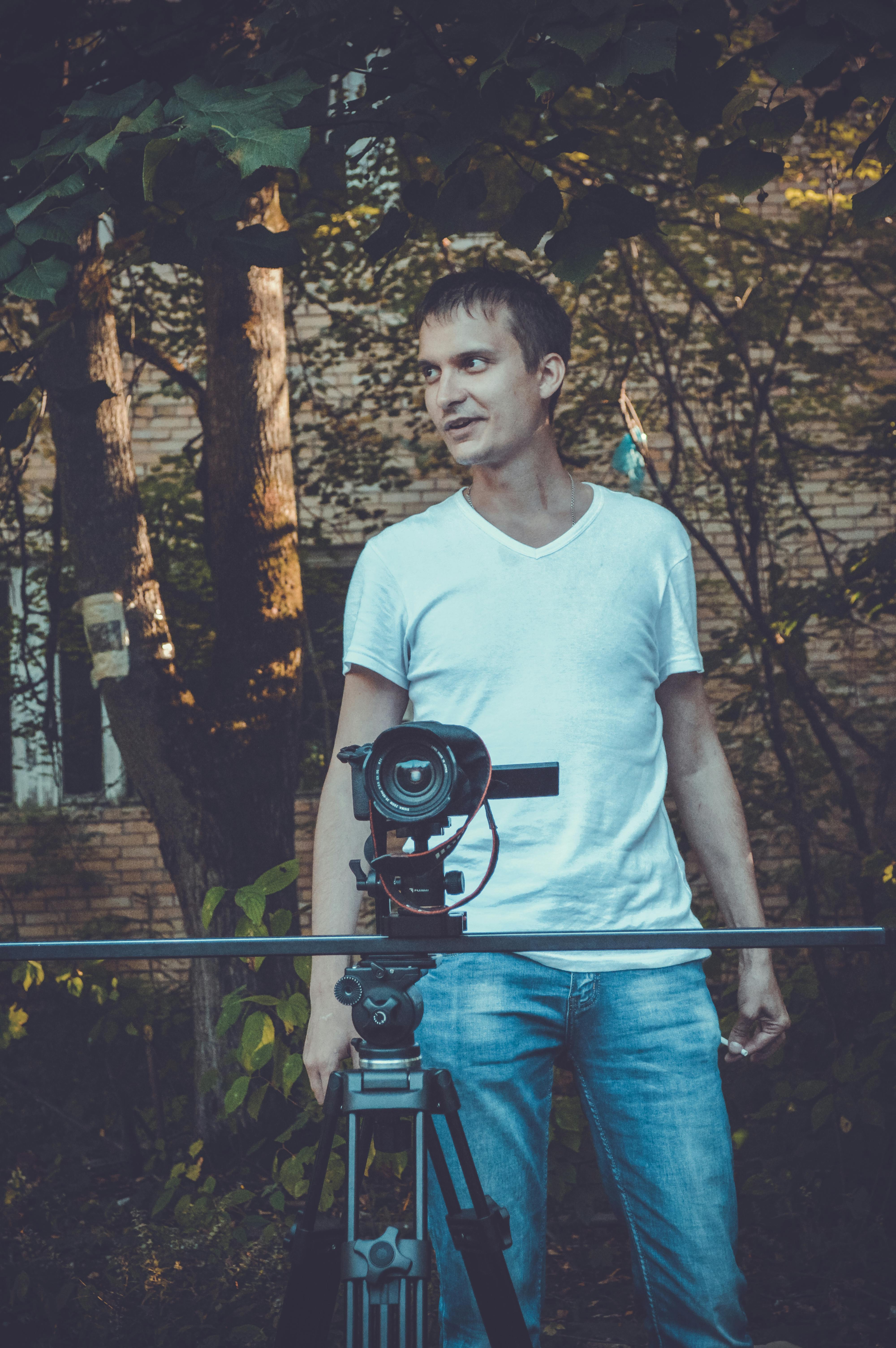 videographer using professional camera in garden