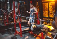 Sporty fitness trainer and man lifting barbell