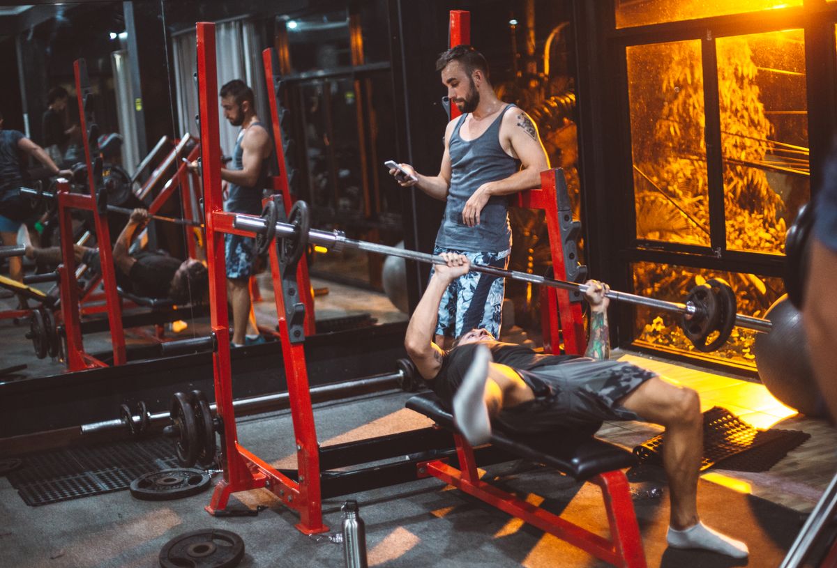 Strength training session with a smartphone in a modern fitness center