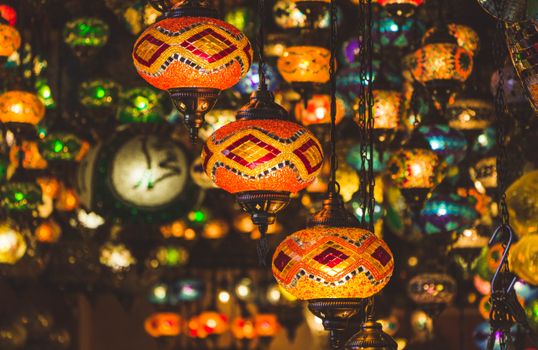 Colorful mosaic lanterns illuminate a market in Istanbul, showcasing traditional Turkish design.