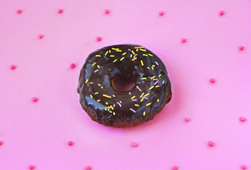 Chocolate Doughnut With Sprinkles on Pink Background