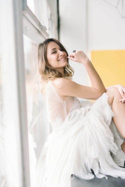 Femme En Robe Blanche Assise Sur Un Canapé Jaune