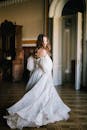 穿着飘逸的礼服的快乐新娘在阳光明媚的历史悠久的房间里优雅地旋转，散发着优雅和浪漫