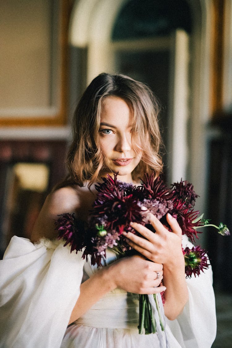 Woman Holding A Bouquet Of Burgundy Flowers