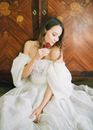 Woman in White Dress Sitting on Brown Wooden Bench
