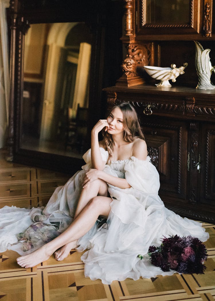 Woman Sitting On The Floor Near The Wooden Framed Mirror 