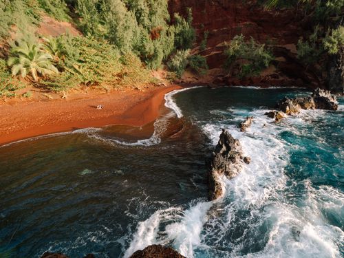 Free Drone view of rough rocky shore of sea with waves rolling over reefs Stock Photo