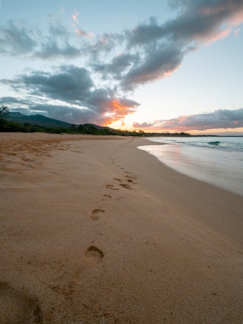 Sandy beach with footprints goes across shoreline