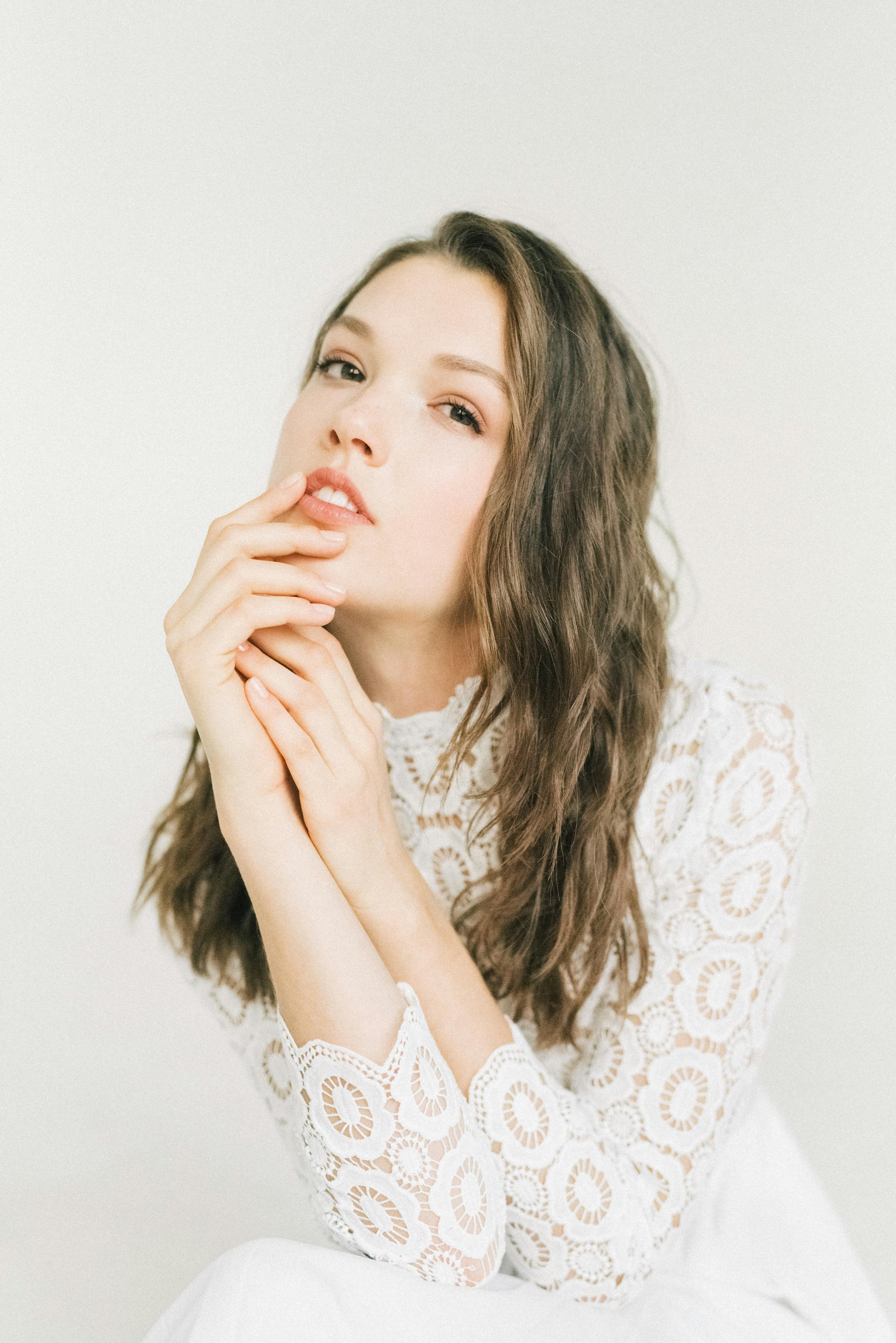 A Woman in White Lace Long Sleeves Posing at the Camera · Free Stock Photo