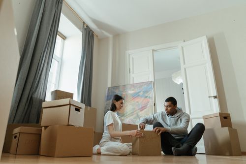 Free A young couple unpacks boxes in their new apartment, starting their domestic journey. Stock Photo