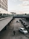 傍晚多云的天空映衬着现代城市景观，汽车和建筑物