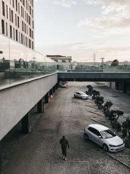 傍晚多云的天空映衬着现代城市景观，汽车和建筑物