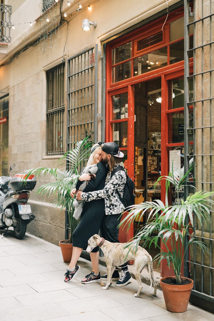 A Couple Cuddling With Their Dog