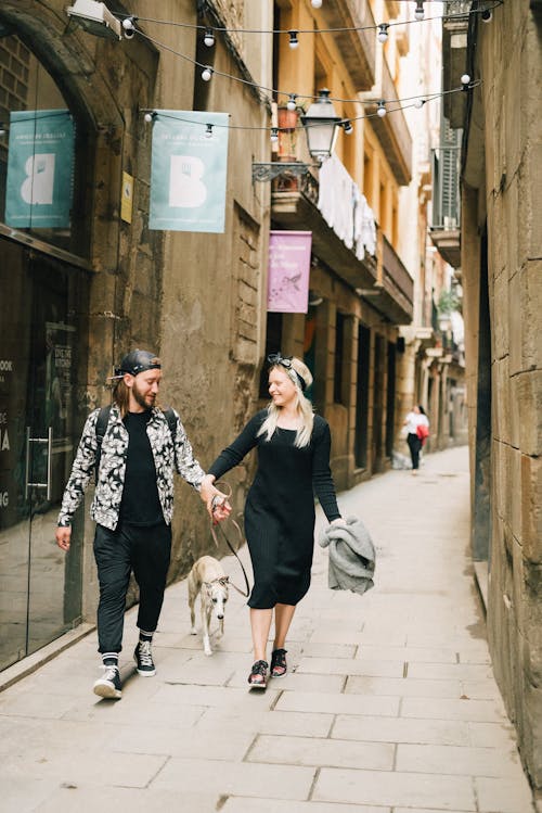 A Couple Walking with a Dog on a Narrow Street