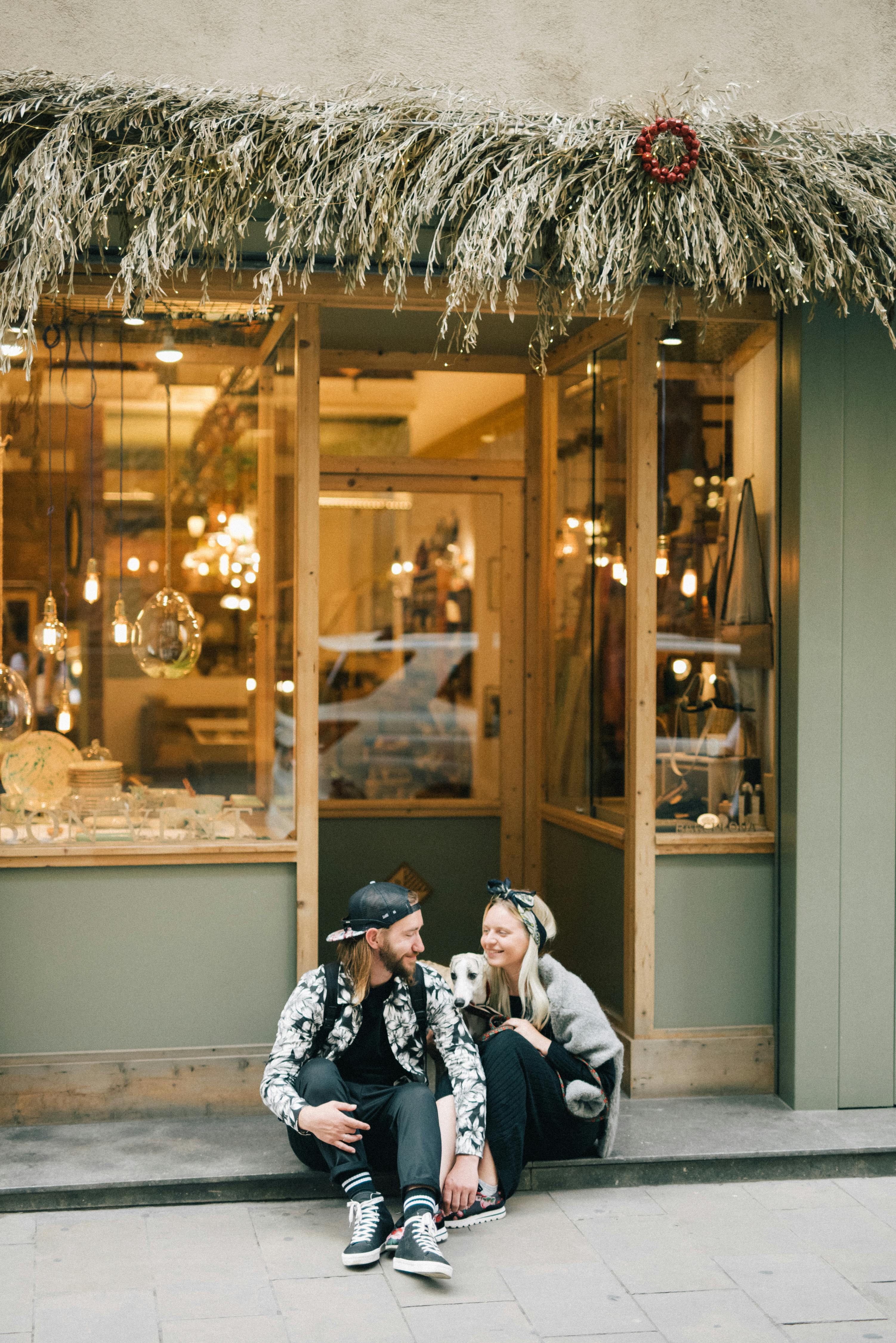 couple holding hands and sitting on the sidewalk