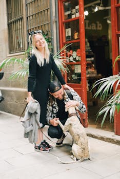 一对快乐的夫妇在一家迷人的城市商店外与他们的狗互动