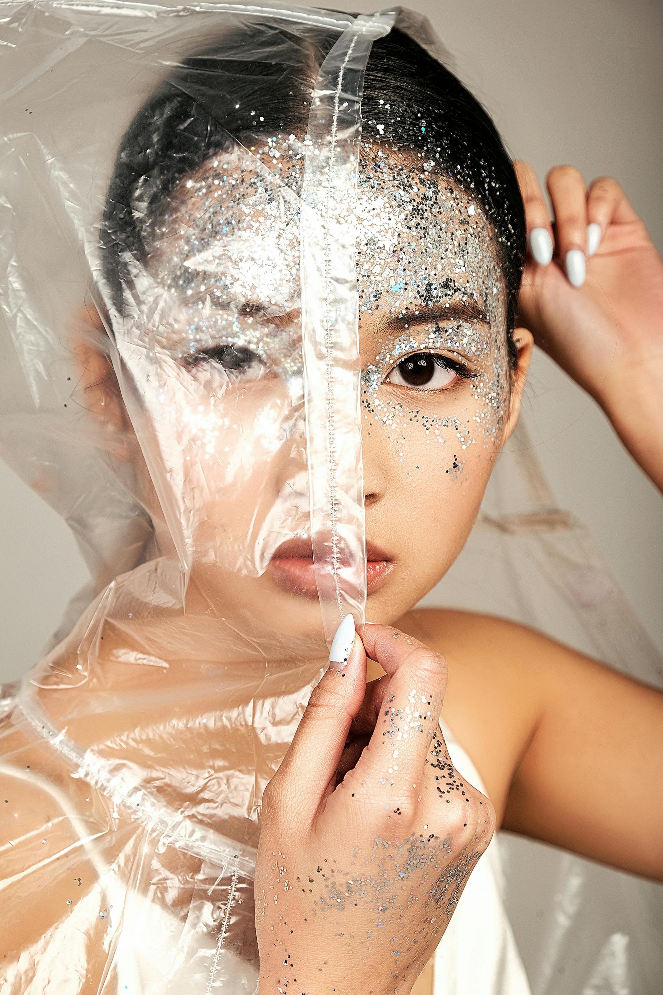 young asian woman face covered of raincoat and tinsel