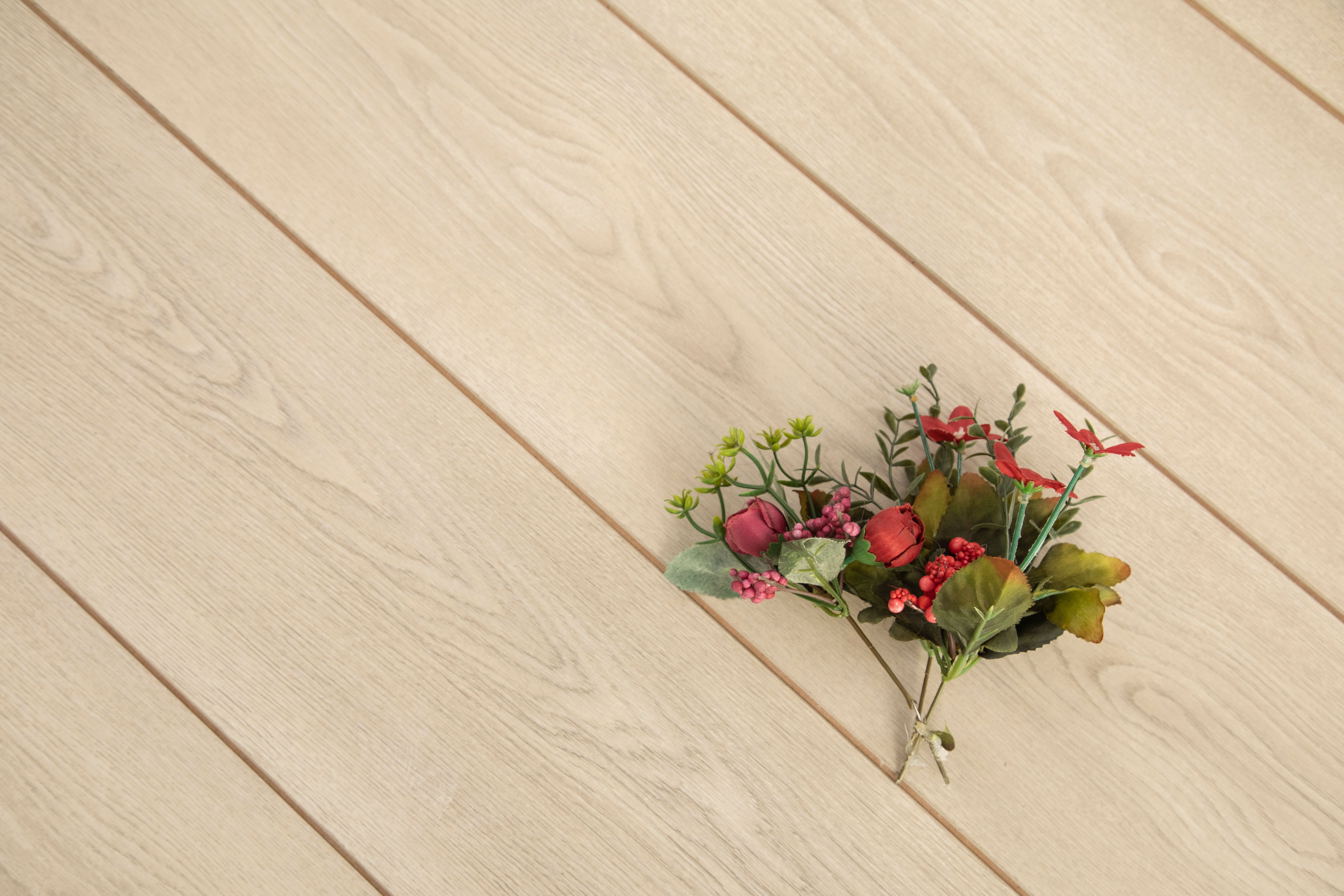 Small bouquet of red flowers on a light wooden tabletop