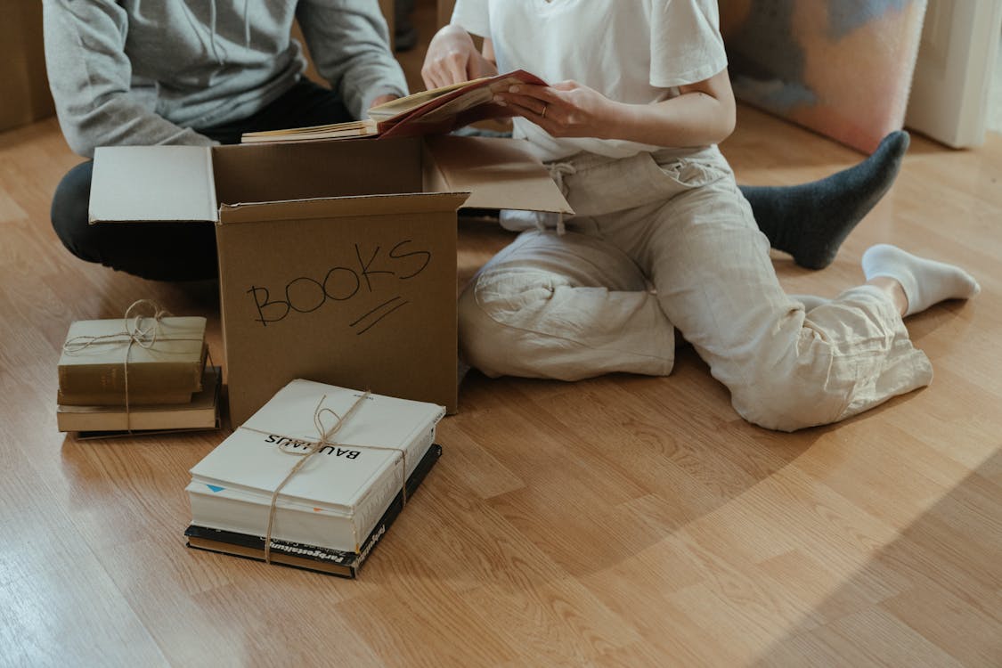 Man in White Dress Shirt and Gray Pants Sitting on Brown Wooden Table