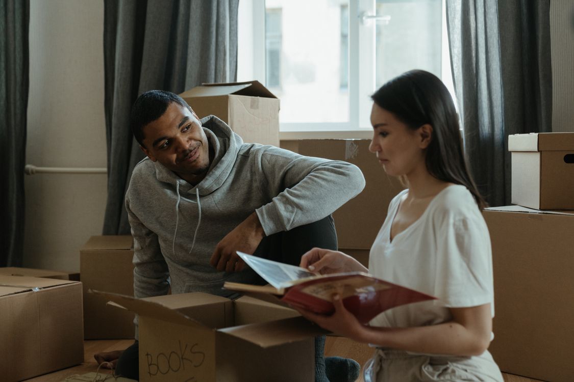 A couple unpacks boxes together while settling into their new home