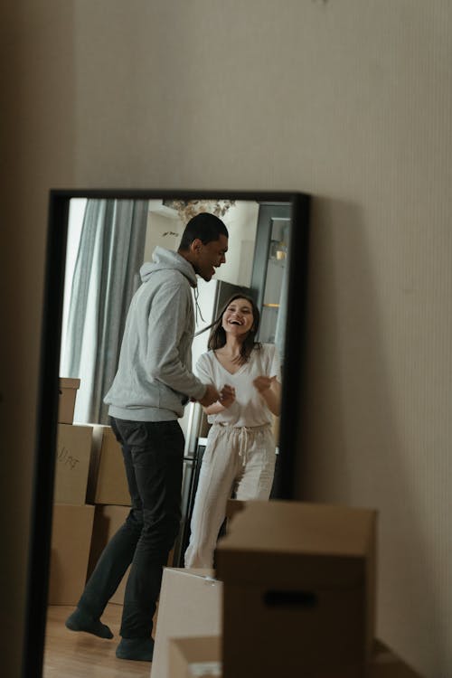 Man in White Dress Shirt and Blue Denim Jeans Standing Beside Woman in White Long Sleeve