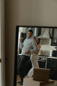Happy couple dancing in their new kitchen, celebrating moving into a new home.