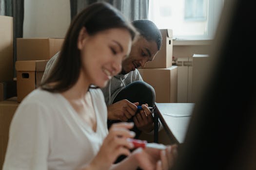 A happy couple assembling furniture in their new apartment surrounded by moving boxes.