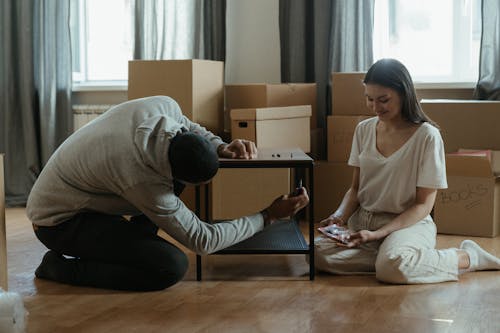 Free Woman in White Long Sleeve Shirt and Black Pants Sitting on Floor Stock Photo